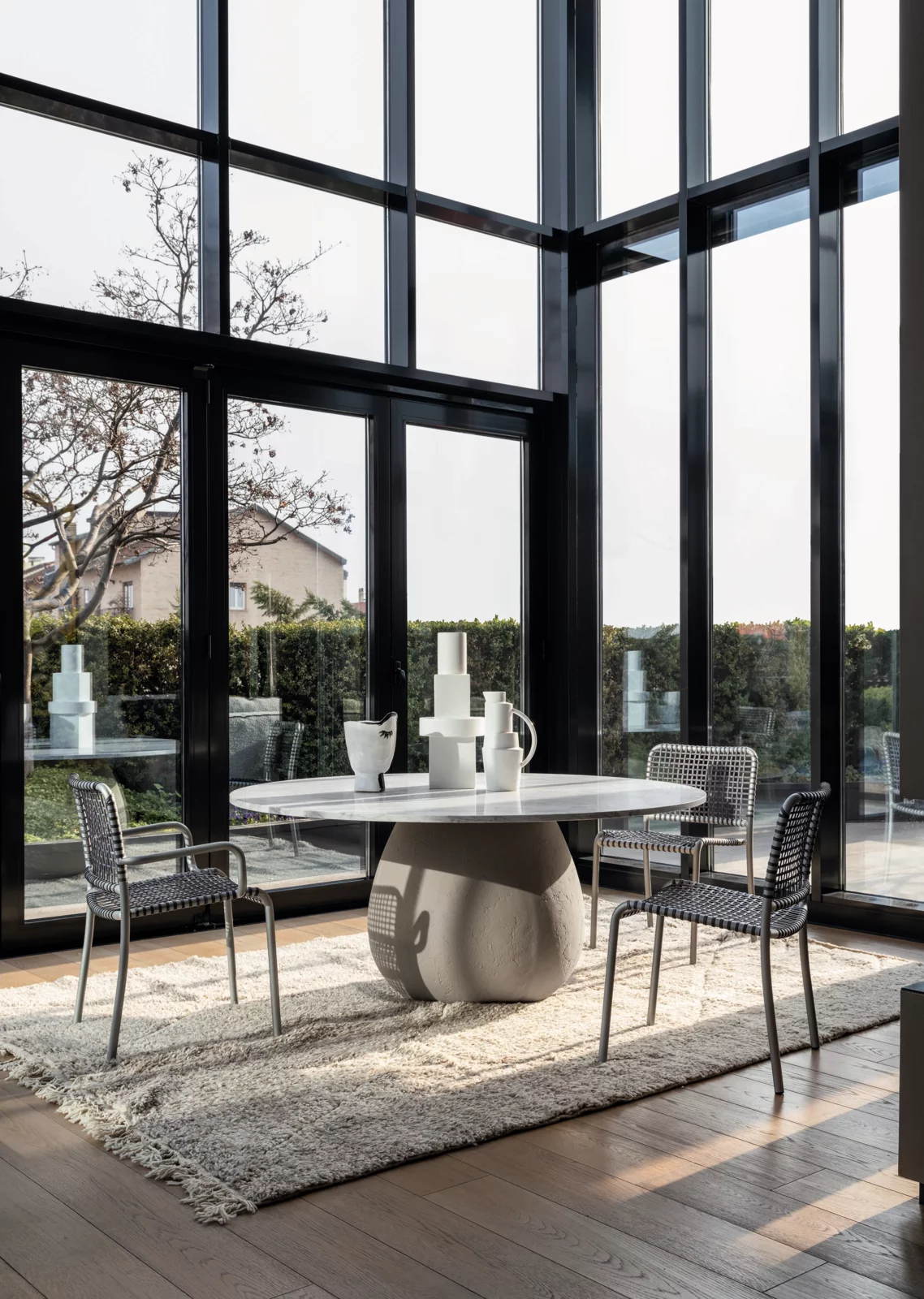 Gervasoni Tisch und Stühle in modernem Esszimmer mit großen Fenstern und Blick auf den Garten