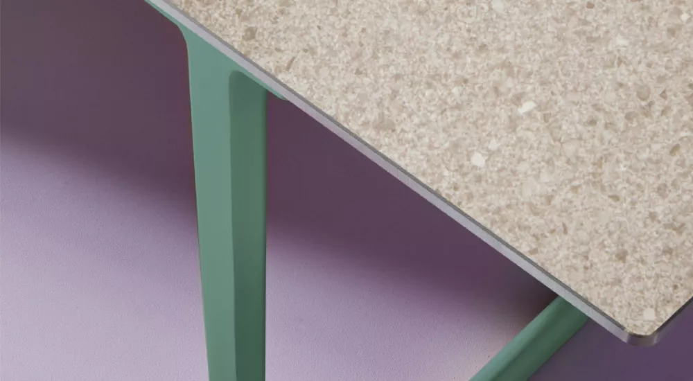 Pedrali Tischplatte in beige Terrazzo-Optik auf grünem Gestell, Detailansicht auf lila Hintergrund, technische Abbildung.