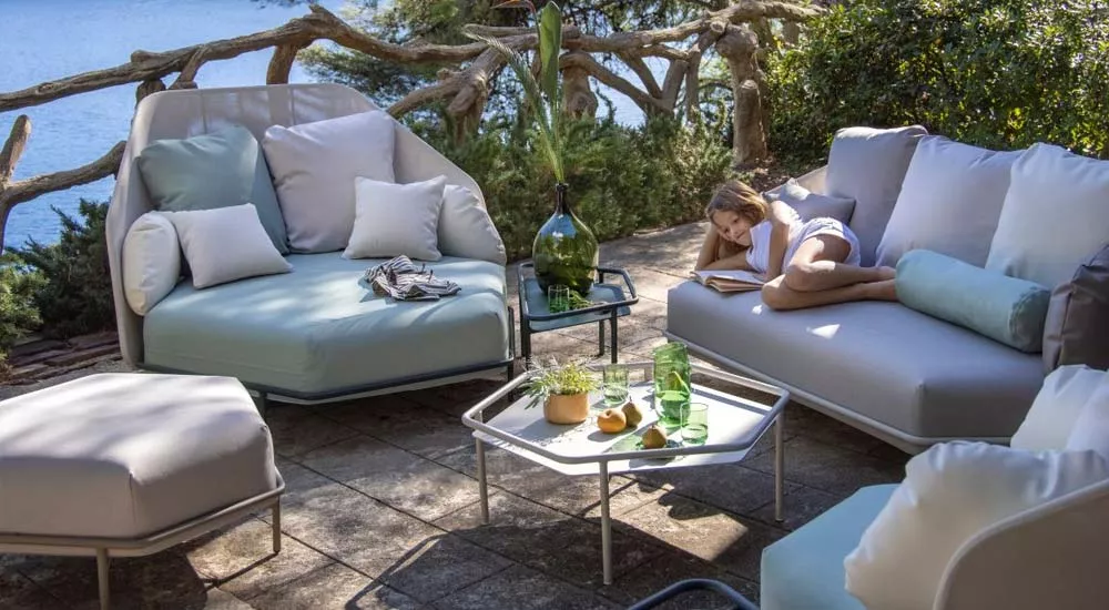 EGO Paris Hive Loungegruppe in Weiß und Hellblau auf einer Terrasse mit Meerblick, stimmungsvolles Bild mit entspannter Atmosphäre.