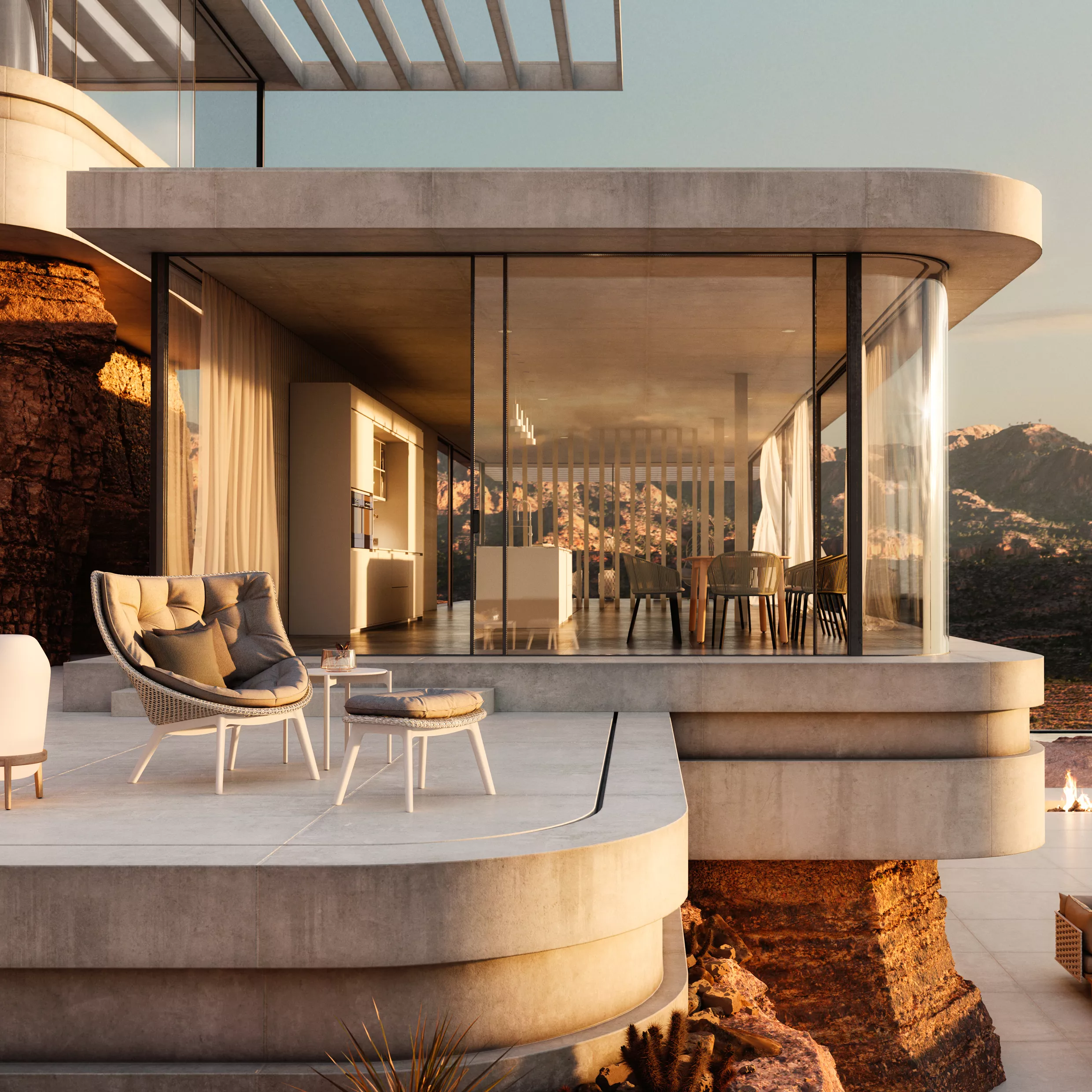 Dedon Mbrace Sessel und Hocker auf einer modernen Terrasse mit Glaswänden und Blick auf eine Berglandschaft bei Sonnenuntergang