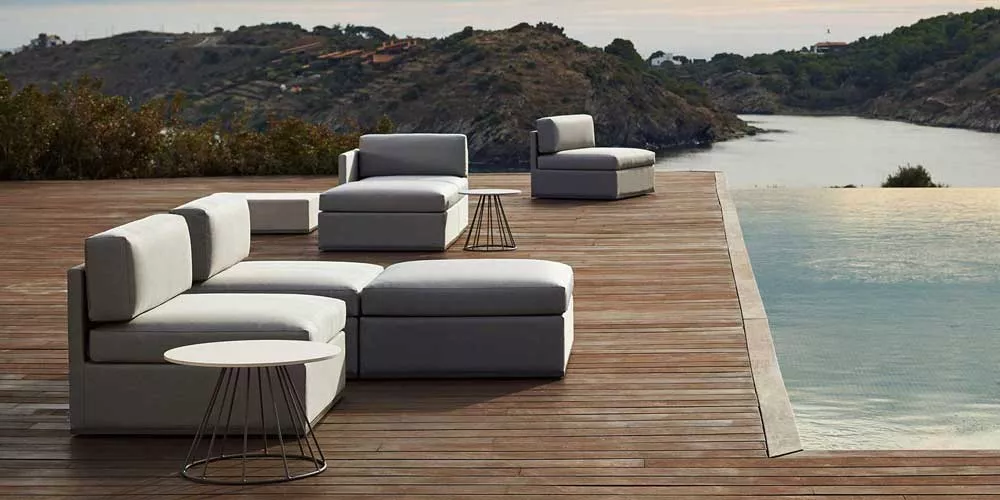 Bivaq Mood Loungegruppe in Grau auf einer Holzterrasse mit Blick auf eine malerische Küstenlandschaft.