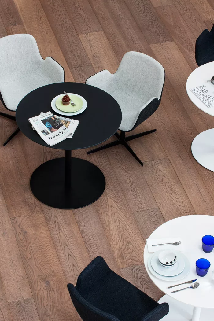 Schwarzer Pedrali Babila Tisch mit grauen Stühlen auf Holzfußboden, Vogelperspektive, mit Zeitung und Dessert auf dem Tisch.