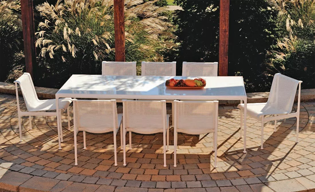 Knoll Studio 1966 Collection Essstuhl und Tisch in einem Garten mit acht Stühlen und einem Obstteller auf dem Tisch