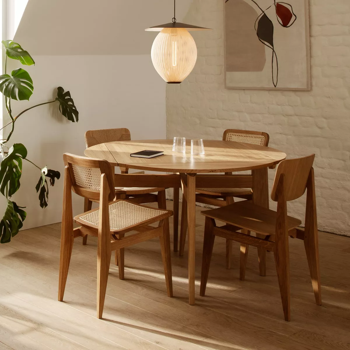 Gubi B Table 116 cm Eiche matt lackiert in einem gemütlichen Esszimmer mit vier Stühlen einer Hängelampe und Pflanzen im Hintergrund