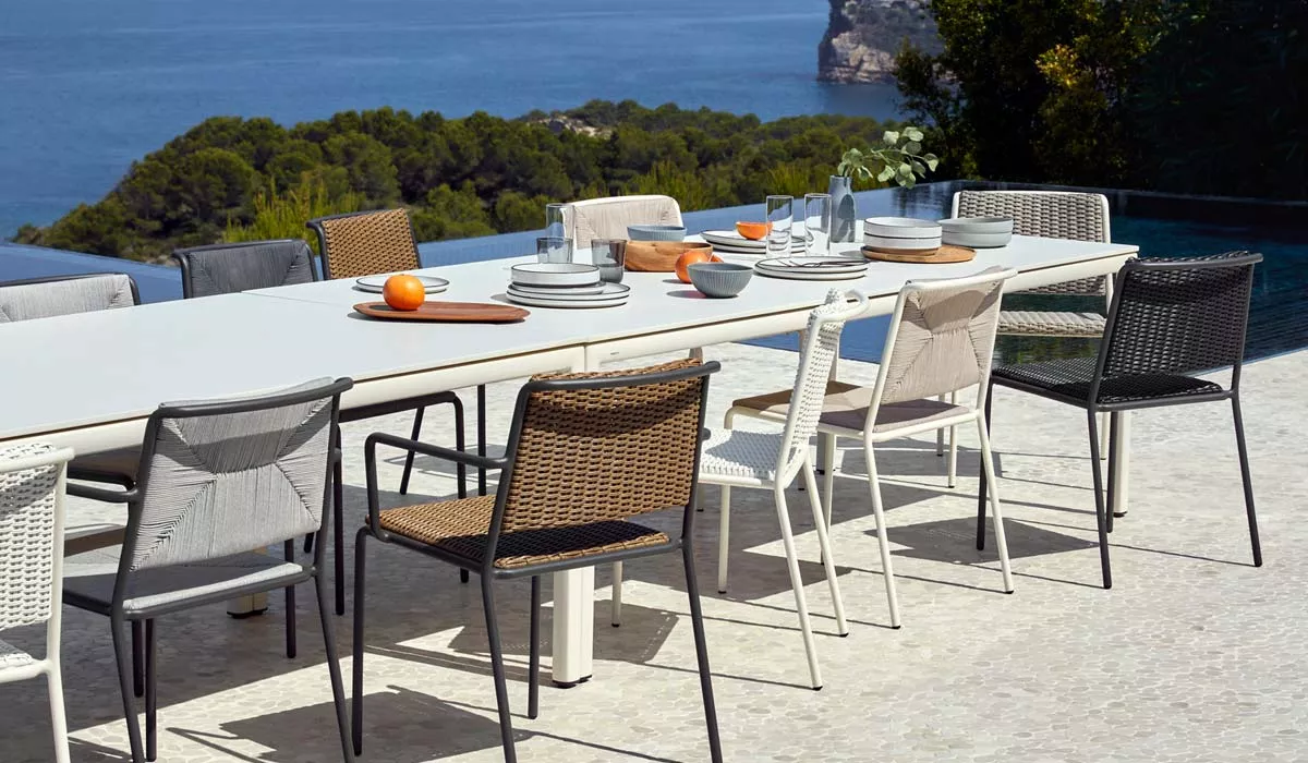 POINT Summer Outdoor Essgruppe in verschiedenen Farben auf einer Terrasse mit Meerblick, ideal für gesellige Runden im Freien.