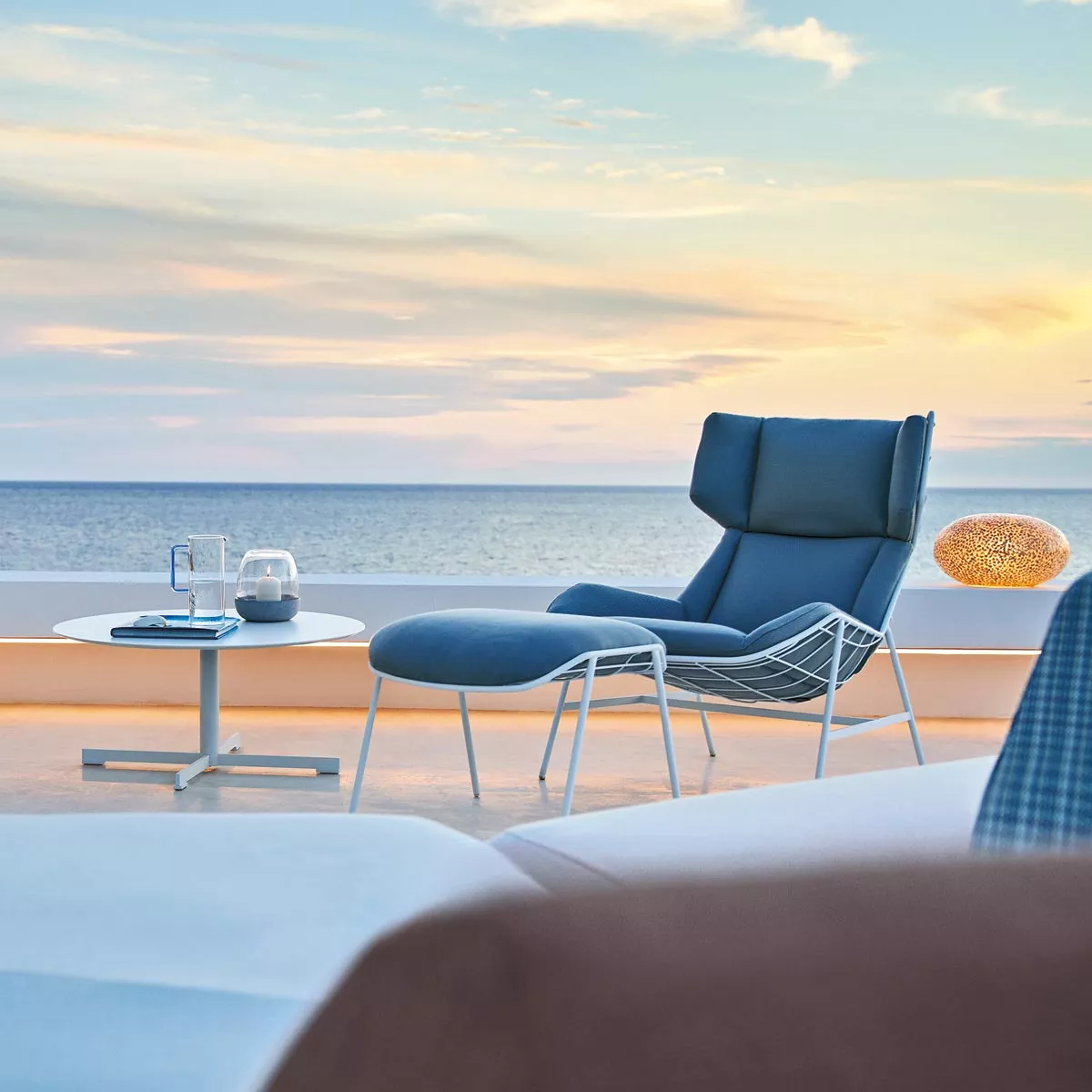 Varaschin Summer Set Loungetisch, 80 cm, mit HPL- oder Marmor-Tischplatte, auf einer Terrasse mit Meerblick bei Sonnenuntergang.