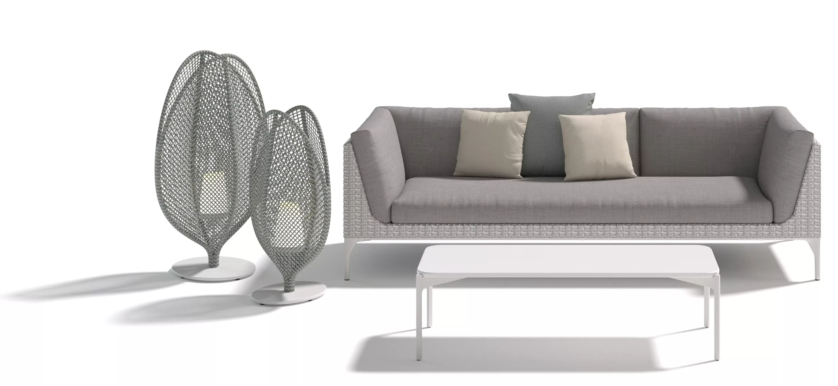 Dedon Mu Sofa in Grau mit weißen und grauen Kissen daneben zwei dekorative Stehleuchten und ein weißer Couchtisch ohne Hintergrund