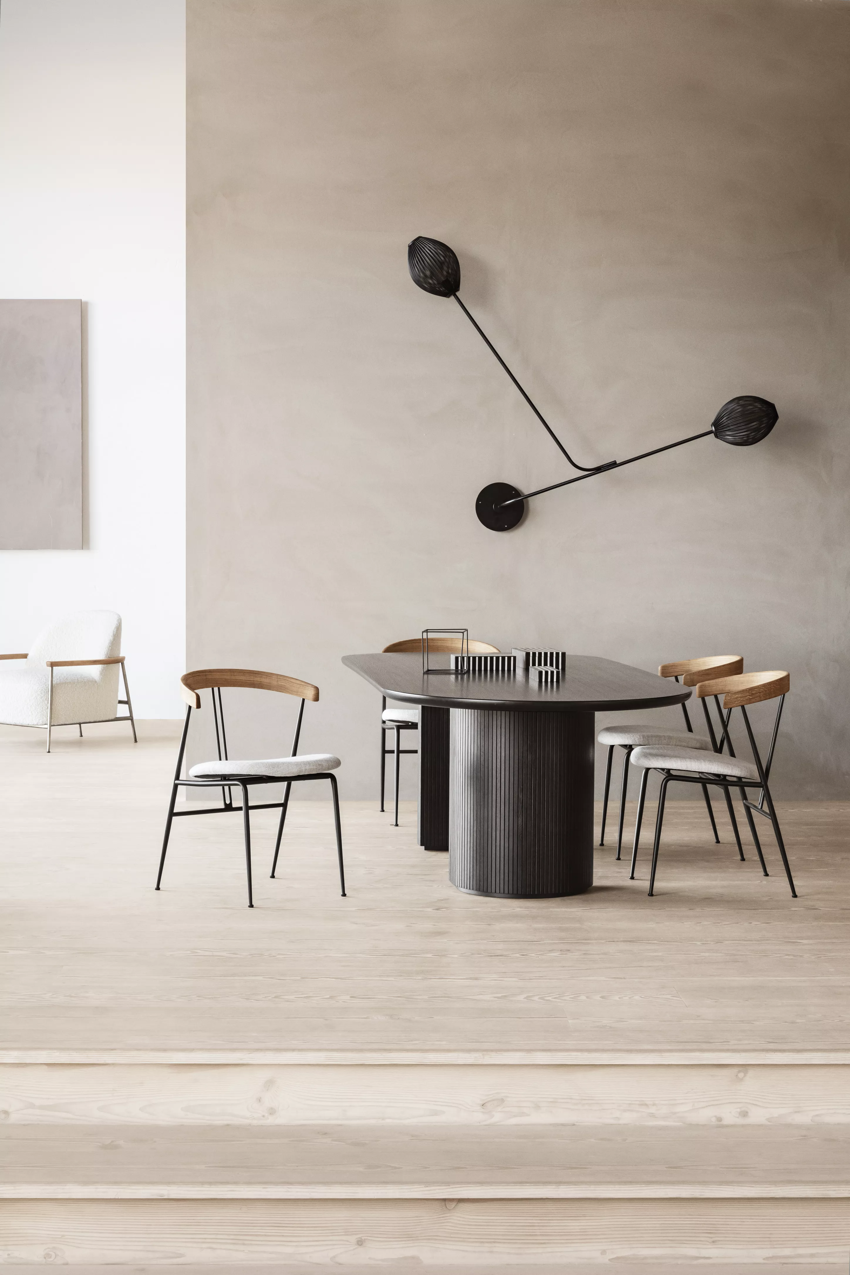 GUBI Borde Tisch und Stühle in einem modernen Wohnzimmer mit minimalistischer Dekoration und Wandkunst im Hintergrund