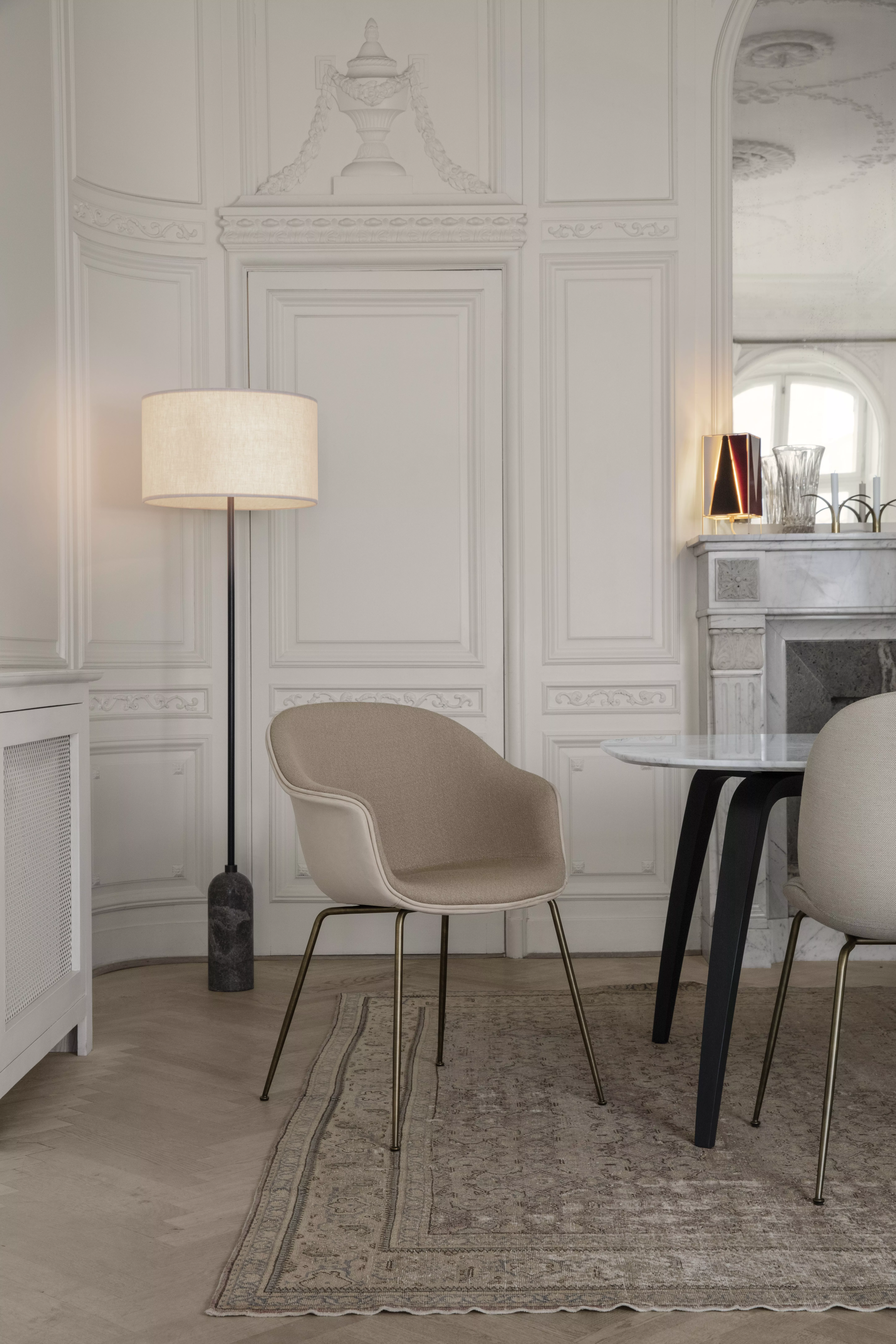 Ein stilvoll eingerichtetes Esszimmer mit GUBI Bat Dining Chair Gravity Floor Lamp GUBI Dining Table und Beetle Dining Chair in einem eleganten Ambiente.