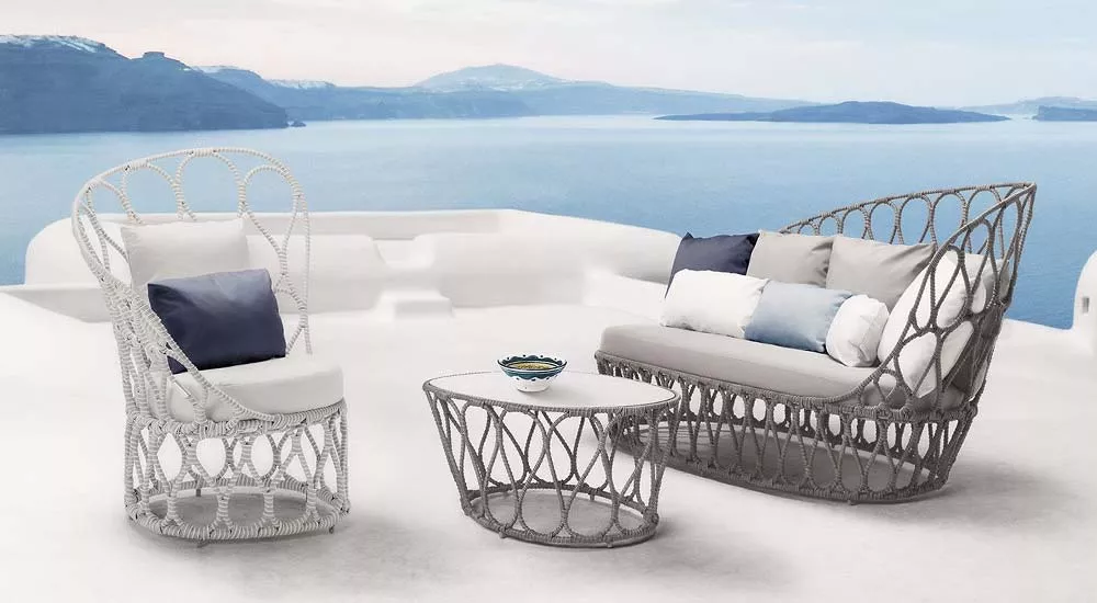 Kenneth Cobonpue Forma Loungegruppe in Grau auf einer Terrasse mit Meerblick, bestehend aus Sofa, Sessel und Tisch, Moodbild.