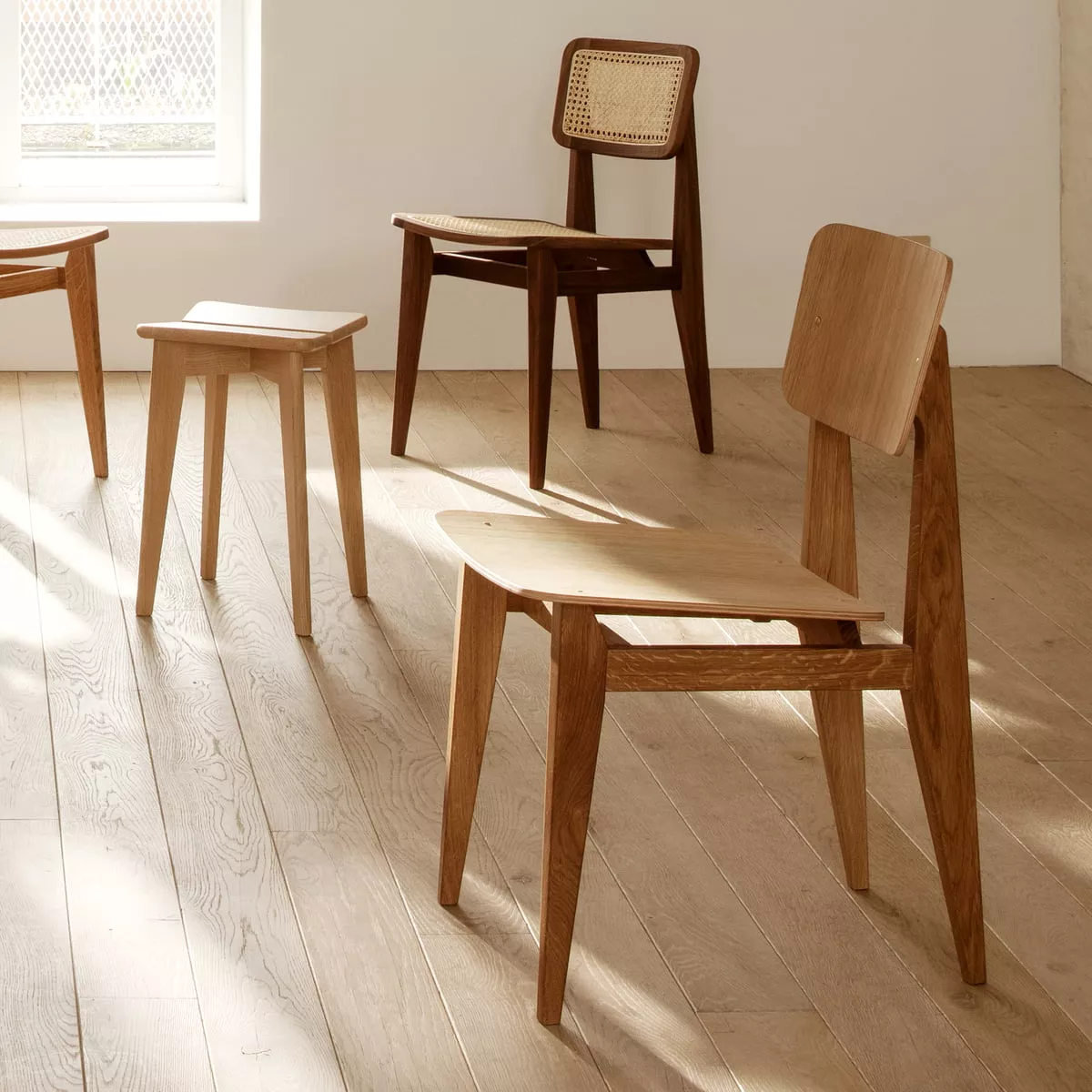 Gubi C-Chair Dining Chair Veneer Eiche geoelt in einem hellen Raum mit Holzboden und weiteren Stühlen im Hintergrund