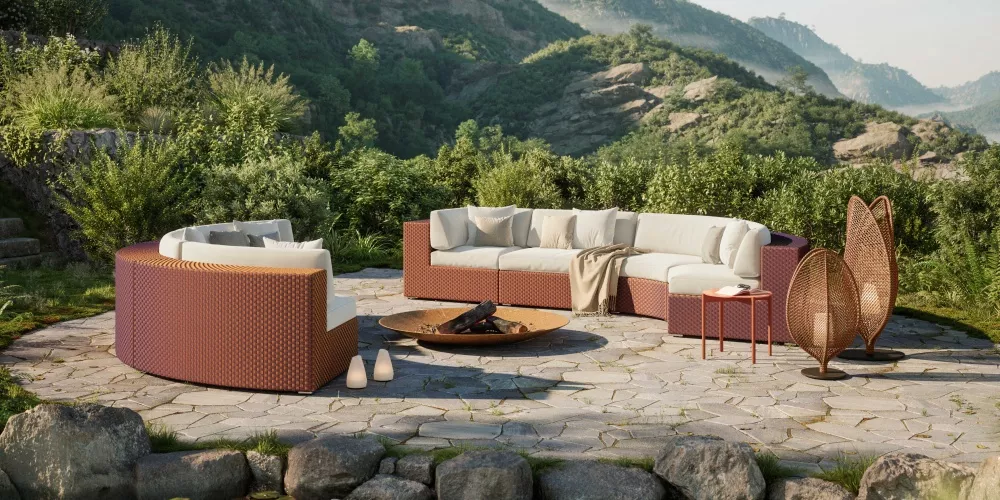 DEDON Lounge Set in einer idyllischen Berglandschaft mit einem runden Sofa einem Couchtisch und einem Feuerplatz im Freien