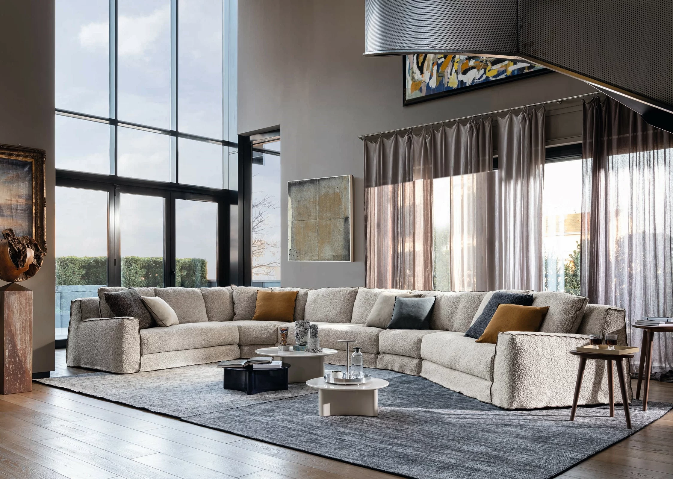 Gervasoni Sofa Ghost, beige, in modern Wohnzimmer mit großen Fenstern und Holzboden, umgeben von stilvollen Dekorationen und Kunstwerken.