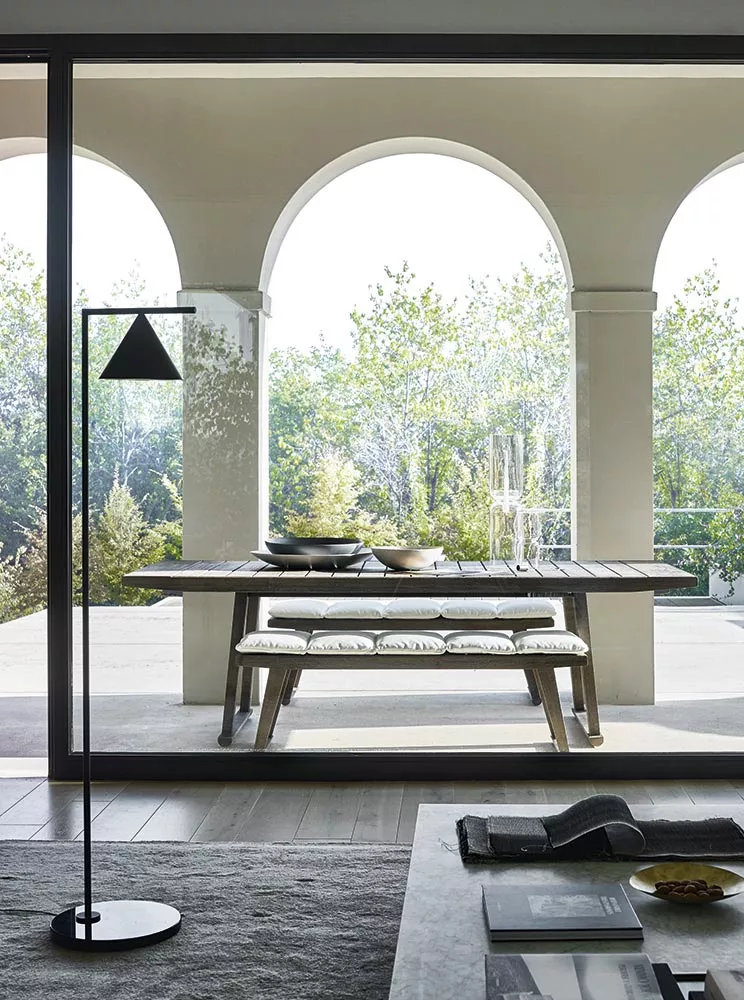 B&B Italia Gio Gartentisch 220 cm auf einer Terrasse mit Blick auf einen Garten und Bogenfenstern im Hintergrund