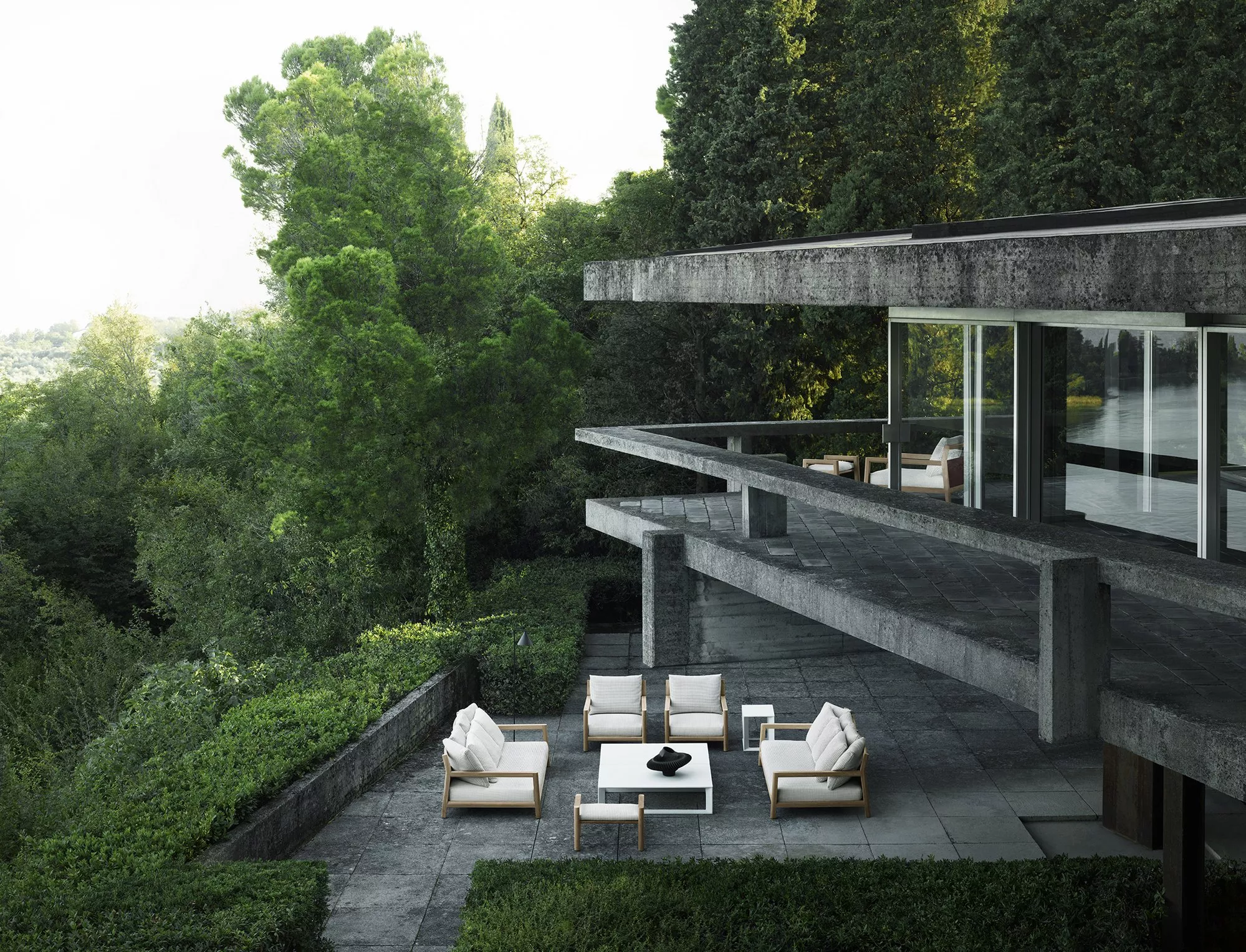 B&B Italia Pablo Outdoor Loungegruppe auf einer modernen Terrasse mit Blick auf einen üppigen grünen Wald