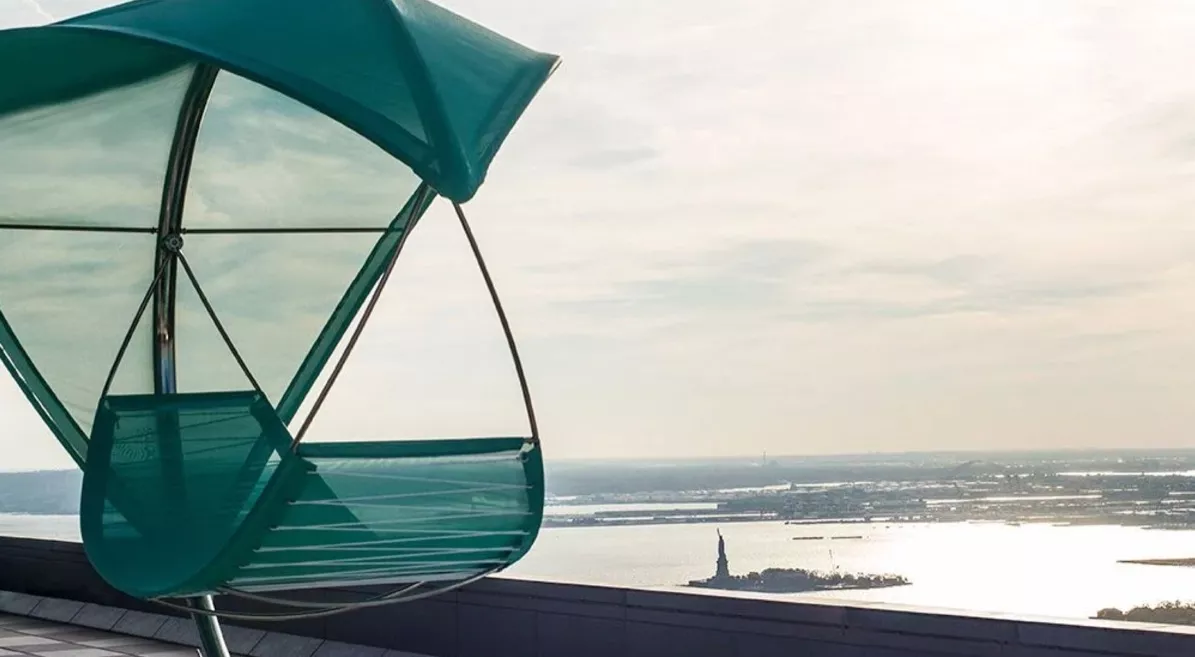 Himmelbett von Villa Schmidt in Türkis auf einer Dachterrasse mit Blick auf die Freiheitsstatue, stimmungsvolles Hintergrundbild.