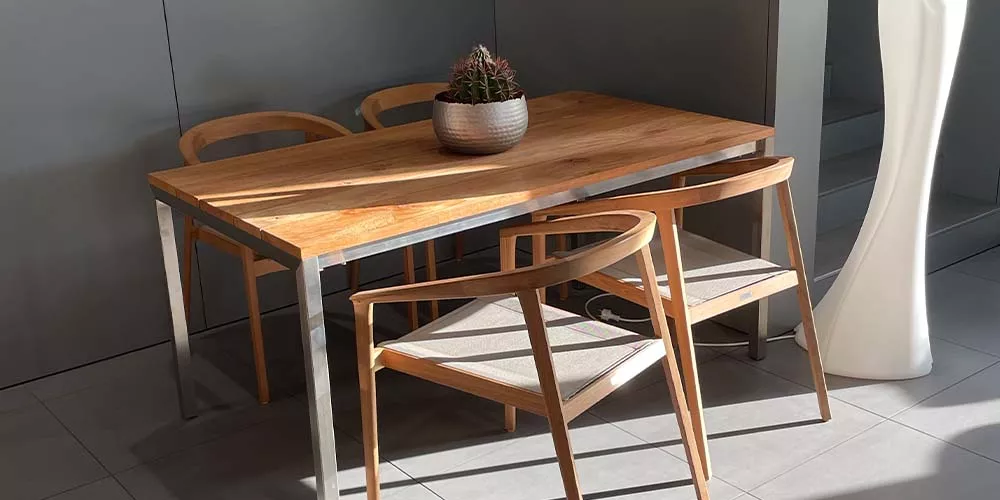 Royal Mirage Vintage Esstisch aus Holz mit Metallrahmen, umgeben von vier Holzstühlen, in einem modernen, lichtdurchfluteten Raum.