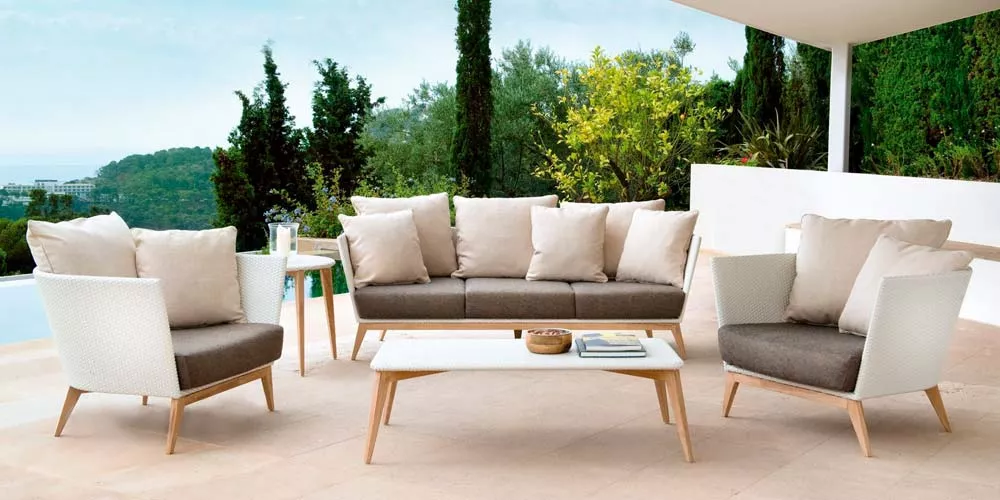 Arc Outdoor Loungegruppe von Point in Weiß und Braun auf einer Terrasse mit Blick auf grüne Landschaft und Pool.