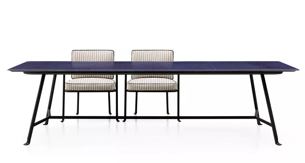 Zwei B&B Italia Borea Gartenstühle mit Armlehnen stehen hinter einem großen rechteckigen Tisch in einem minimalistischen Raum ohne Hintergrund