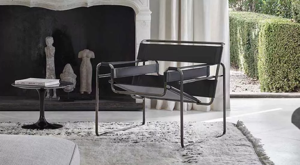 Schwarzer Knoll Wassily Chair in modernem Wohnzimmer mit Teppich und Skulpturen im Hintergrund, Tageslicht durch Fenster.