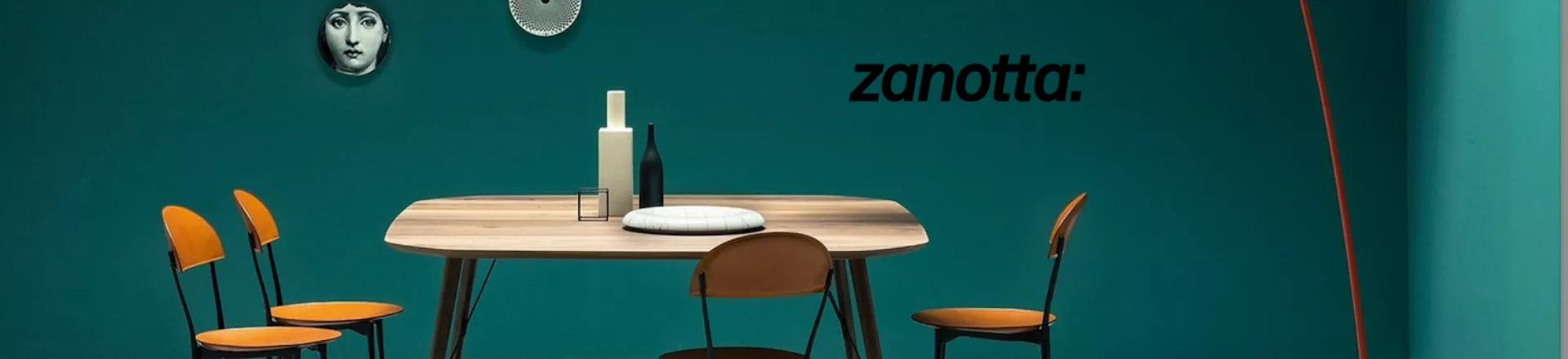 Esszimmer mit Zanotta Tisch und Stühlen in einem modernen Raum mit grüner Wand und dekorativen Tellern an der Wand