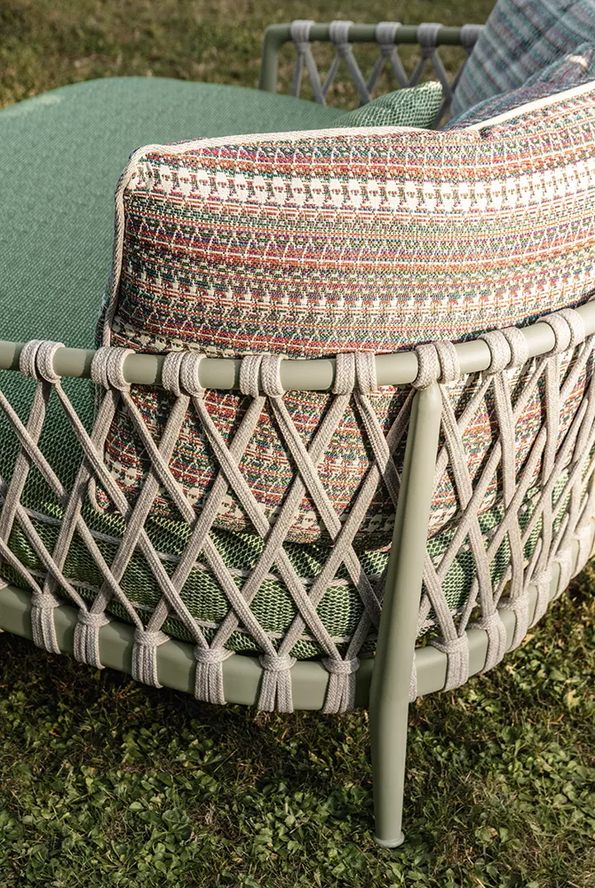 B&B Italia Erica 19 Outdoor Lounge mit grünem Kissen und gemustertem Rückenkissen auf einer Wiese im Freien