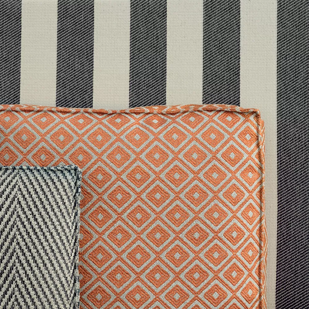 B&B Italia I Oh It Rains Sessel mit orangefarbenem geometrischem Muster und gestreiftem Hintergrund mit Textilien in Nahaufnahme