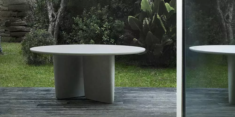 BeB Italia Tobi ishi Tisch steht auf einer Terrasse im Garten umgeben von Pflanzen und Bäumen im Hintergrund spiegelt sich die Umgebung im Fenster