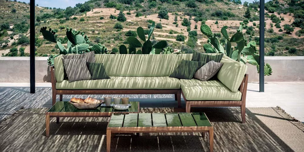 Roda Teka Loungegruppe in Grün auf Terrasse mit Kaktushintergrund, bestehend aus Ecksofa und Couchtisch, sommerliche Atmosphäre.
