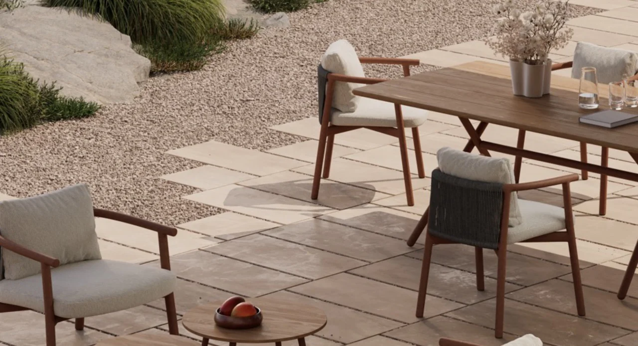 Bivaq Balm Gartenmöbel-Set in Naturtönen auf einer Terrasse mit Steinplatten und Kies, umgeben von Pflanzen.