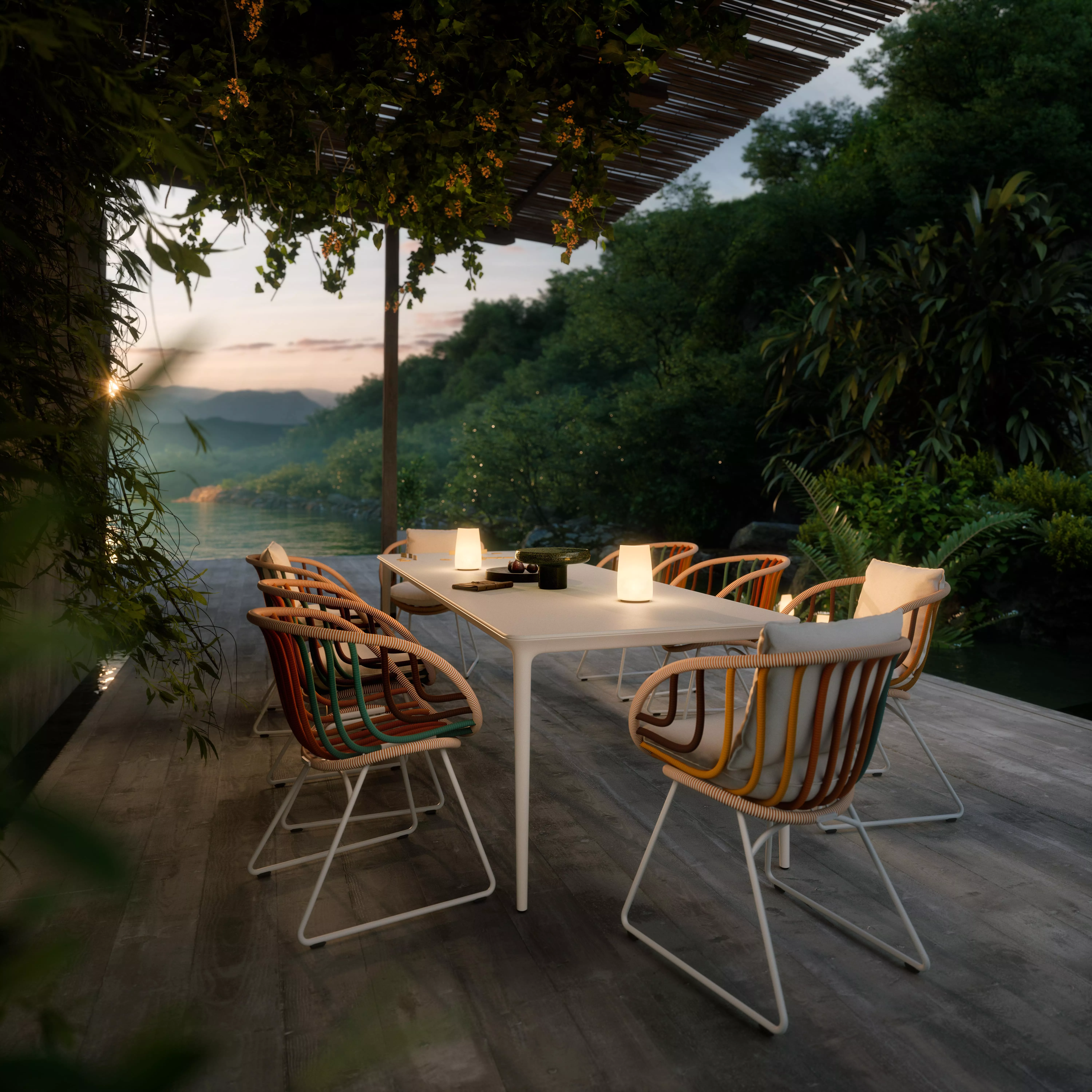 Dedon Spiritual Mountain Bellmonde Kida Ombii Stühle und Tisch auf einer Terrasse mit Blick auf bewaldete Berge bei Sonnenuntergang stimmungsvolles Bild