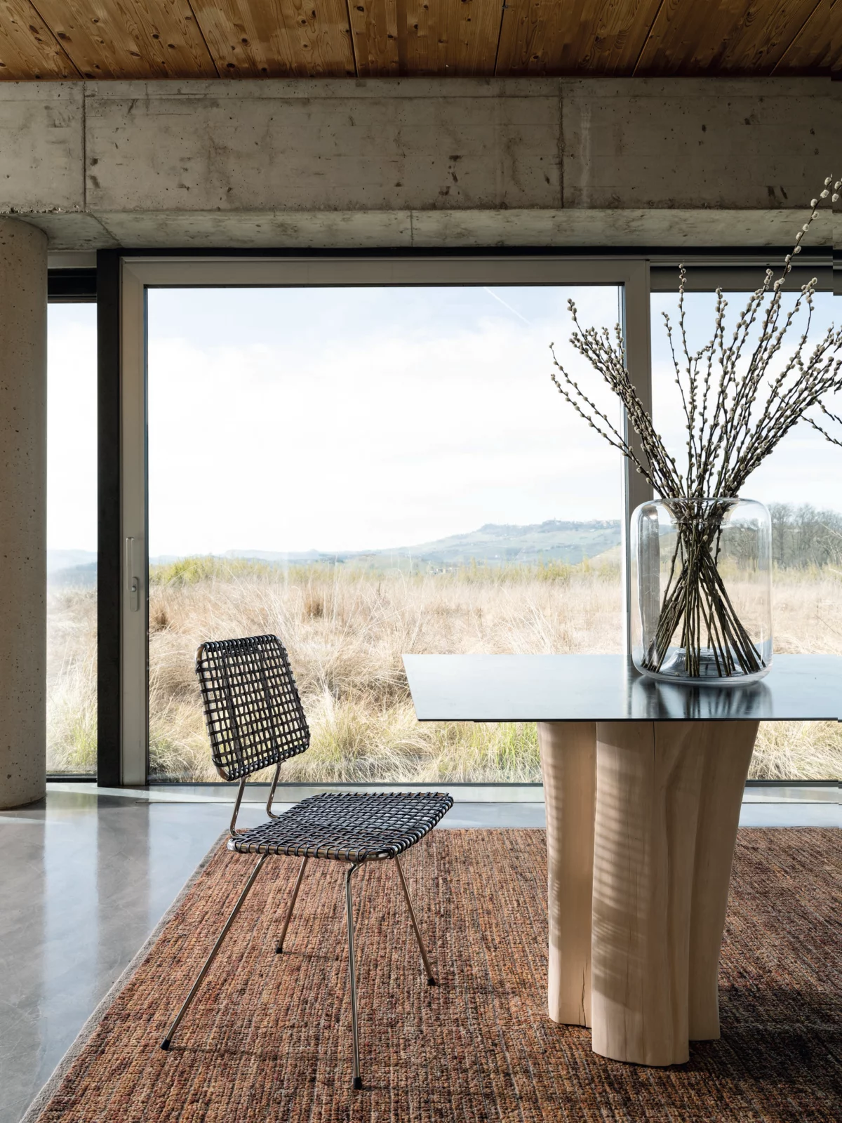 Gervasoni Stuhl und Tisch in modernem Raum mit großem Fenster und Blick auf die Natur