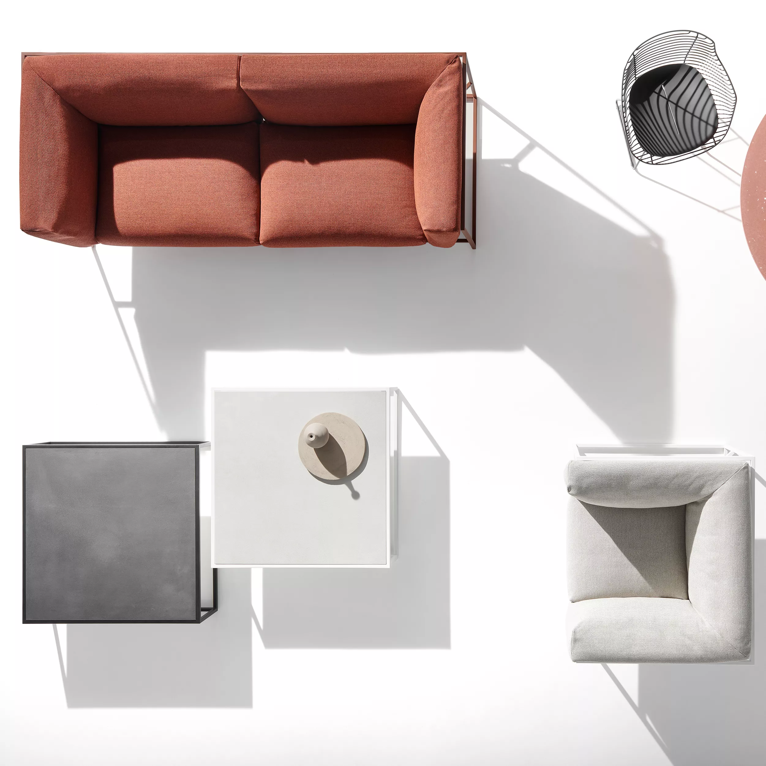 MDF Italia Arpa Loungesessel in einer modernen Wohnzimmerumgebung mit einem roten Sofa einem Couchtisch und einem Beistelltisch von oben fotografiert