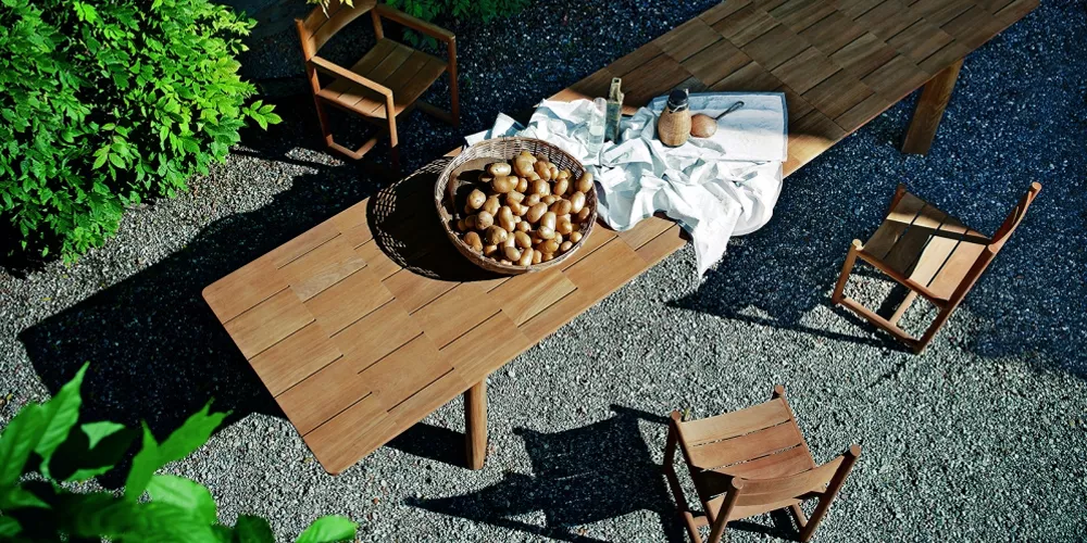 Roda Kollektion Brick, brauner Holztisch mit Stühlen, Gartenhintergrund, Vogelperspektive.