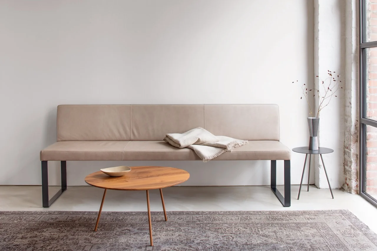 Beige Villa Schmidt BOP Bank auf hellem Teppich vor weißer Wand, mit Holztisch und Vase im modernen Wohnzimmer.