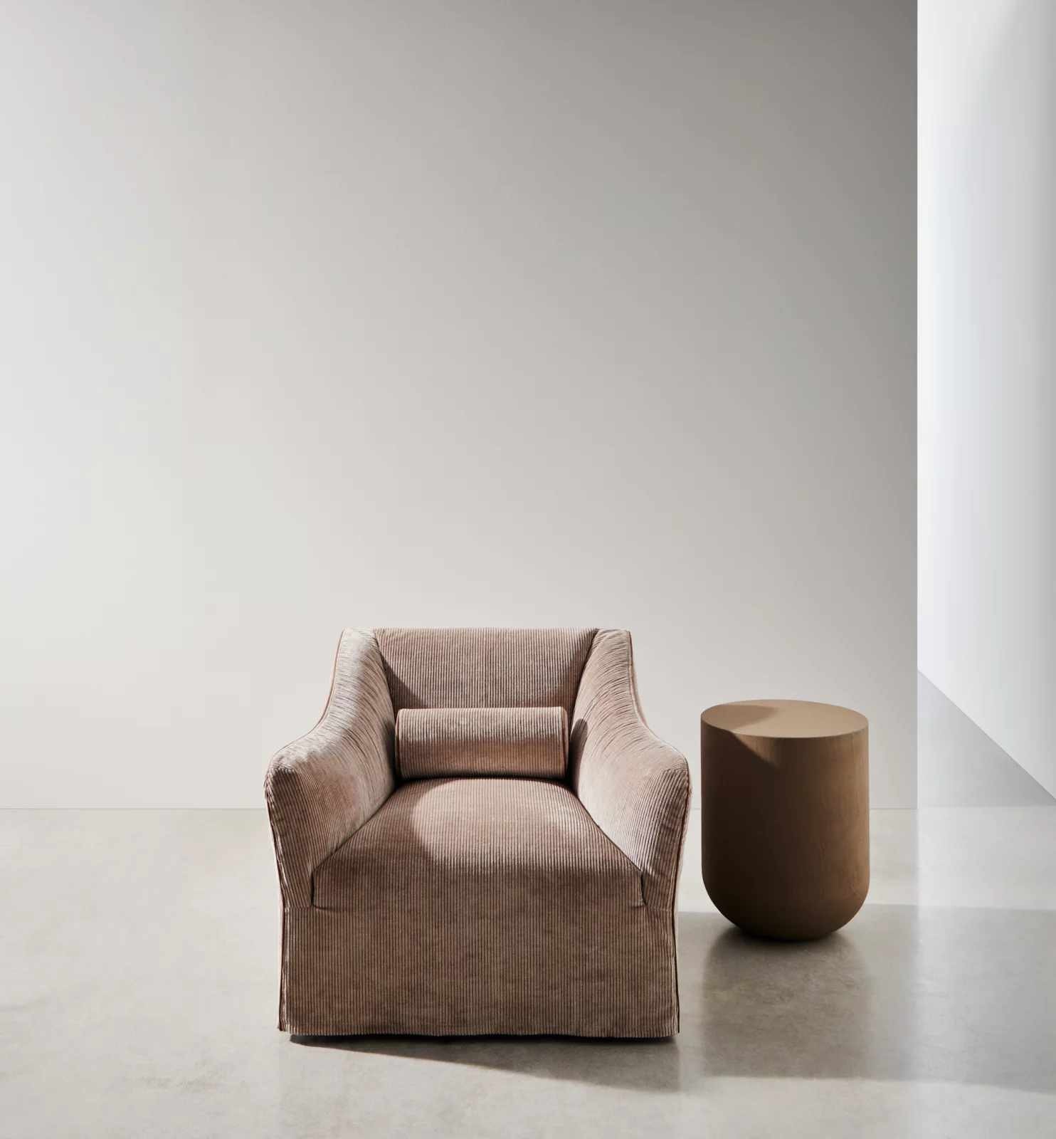 Gervasoni Ghost 05 Sessel in Beige mit passendem runden Beistelltisch in einem minimalistischen Raum ohne Hintergrund