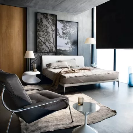 Zanotta Talamo Bett in Weiß mit Lattenrost in modernem Schlafzimmer, Betonwänden und stilvollen Dekorationen, stimmungsvolle Atmosphäre.