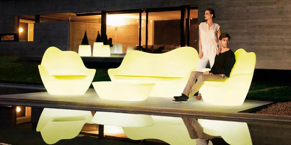 Vondom Sabinas Loungegruppe in leuchtendem Gelb auf einer Terrasse vor einem modernen Haus bei Nacht.
