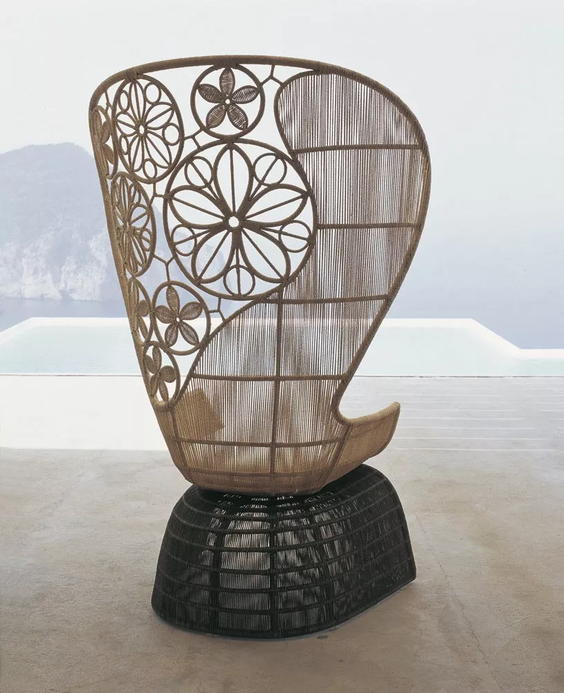 B&B Italia Crinoline Outdoor Sessel mit Abakageflecht steht auf einer Terrasse mit Blick auf das Meer und die Berge im Hintergrund