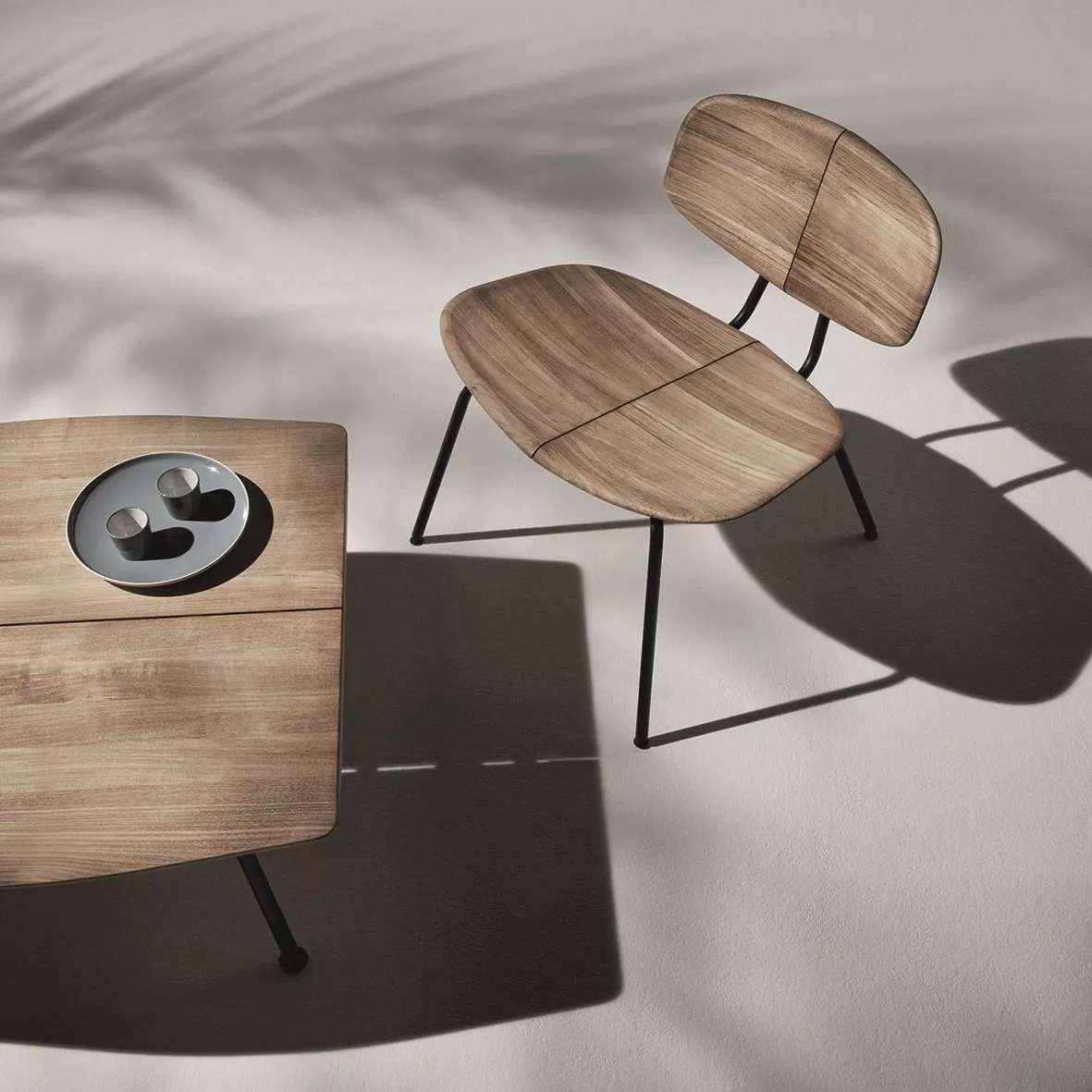 Ethimo Agave Gartensessel in Holzoptik, Teil einer Loungegruppe, auf hellem Hintergrund mit Schatten, aus der Vogelperspektive.