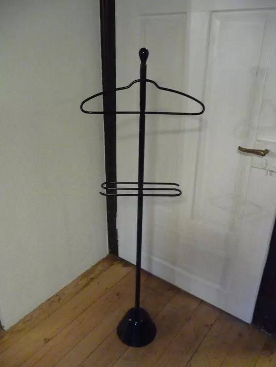 Zanotta Servonotte Kleiderständer in einem Raum mit Holzboden und weißer Tür im Hintergrund.