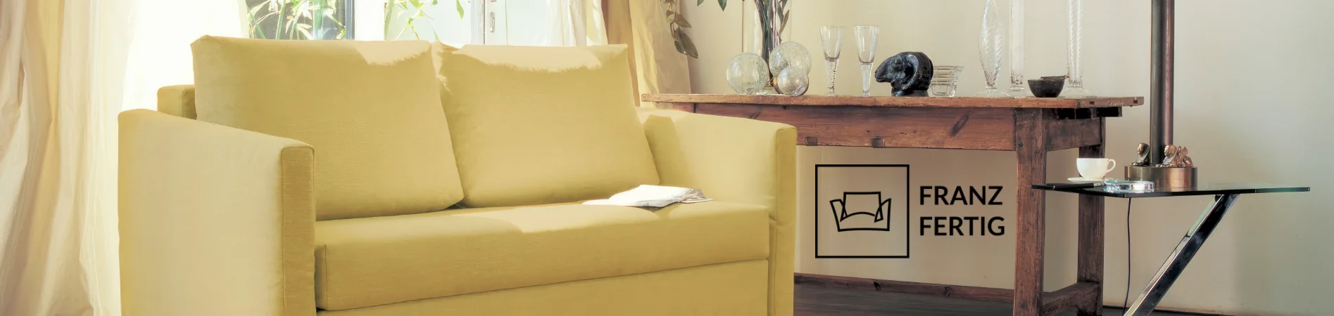 Gelbes Franz Fertig Sofa in gemütlichem Wohnzimmer mit Holztisch und Dekorationen, stimmungsvolle Beleuchtung durch Vorhänge.