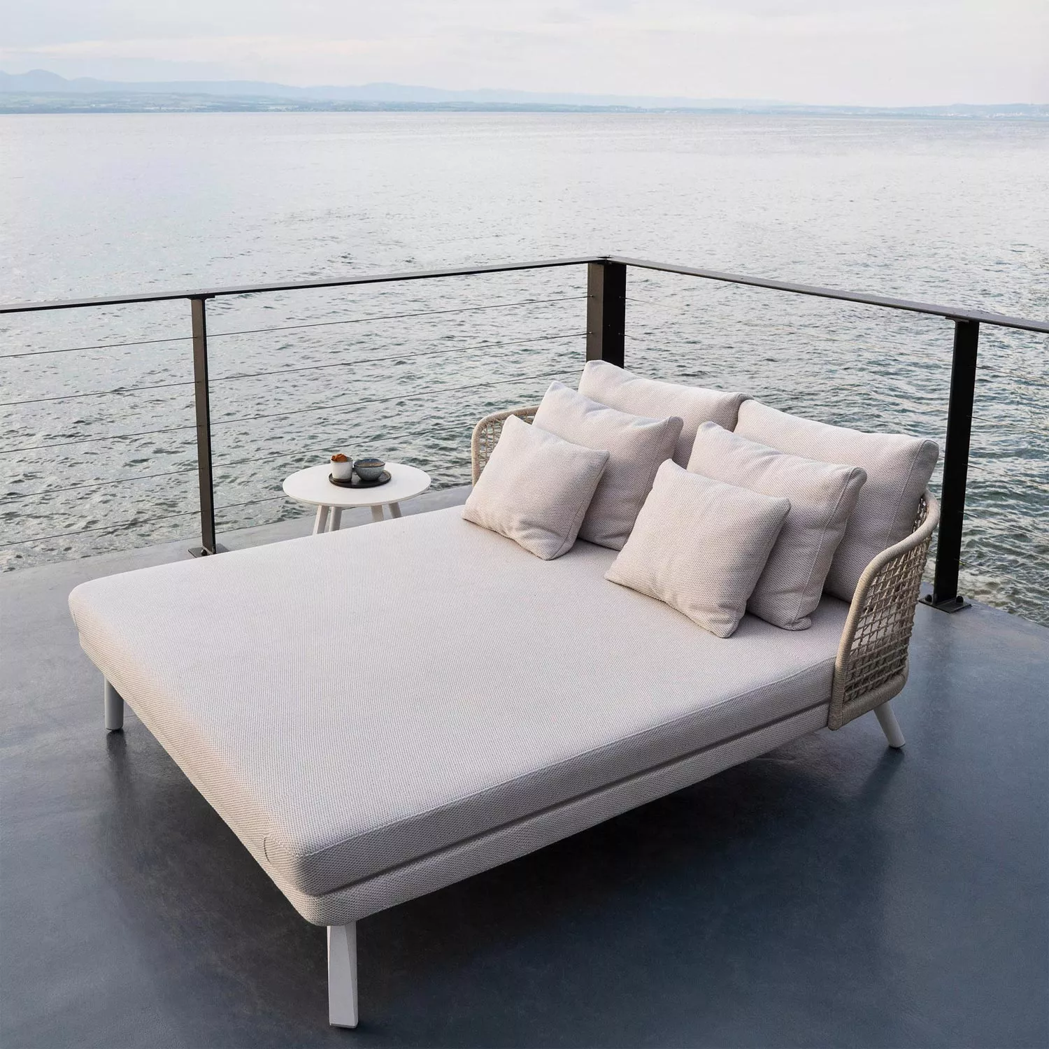 Varaschin Emma Daybed, Doppel-Sonnenliege in Beige, 161x190 cm, auf Terrasse mit Meerblick, entspannte Atmosphäre.