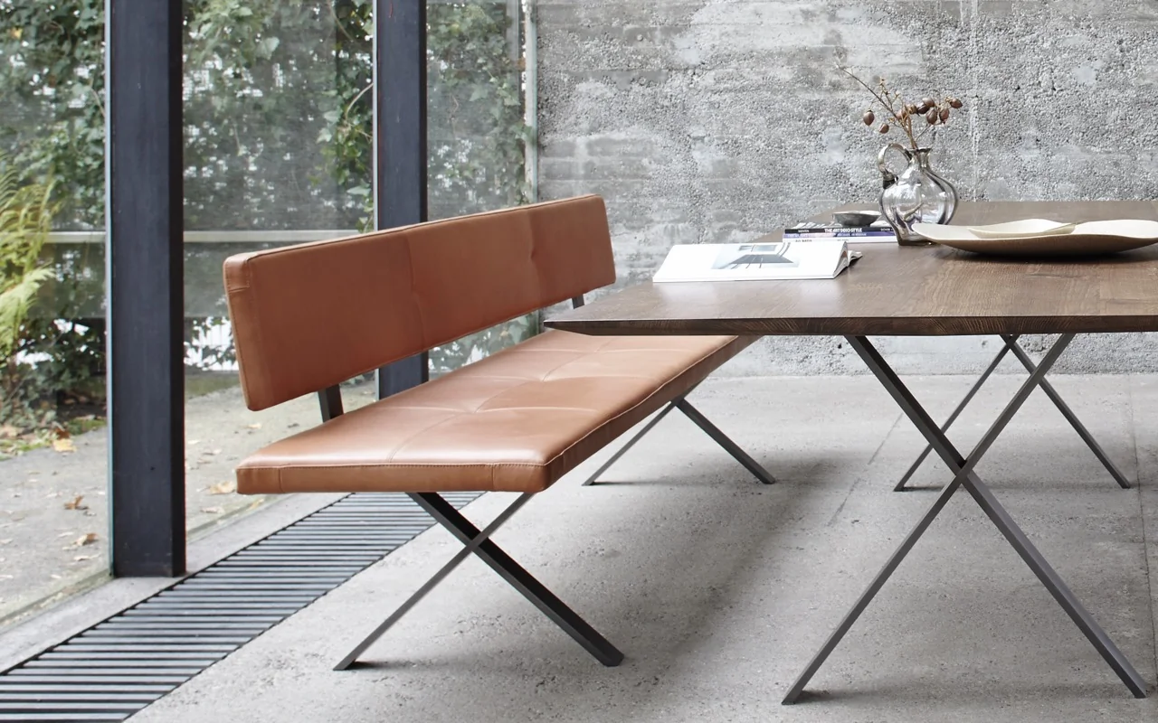 Braune LAX Bank von VS_more in modernem Esszimmer mit Betonwand und großem Fenster, seitliche Perspektive.