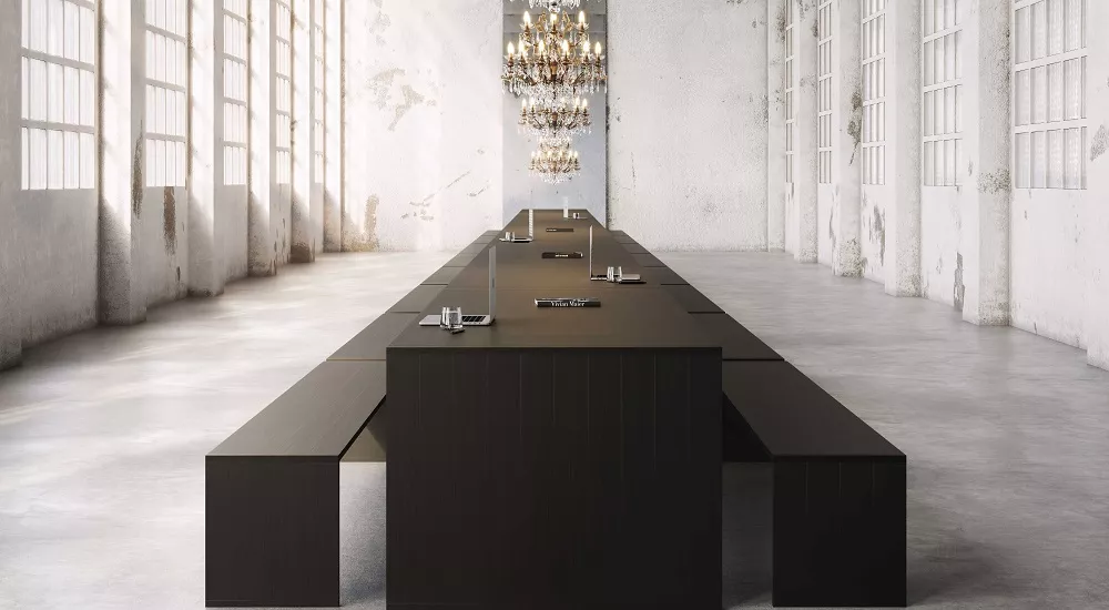 Schwarzer, eloxierter gbmodular Esstisch 210 mit Bank 200 in einem industriellen Loft mit hohen Fenstern und Kronleuchtern.