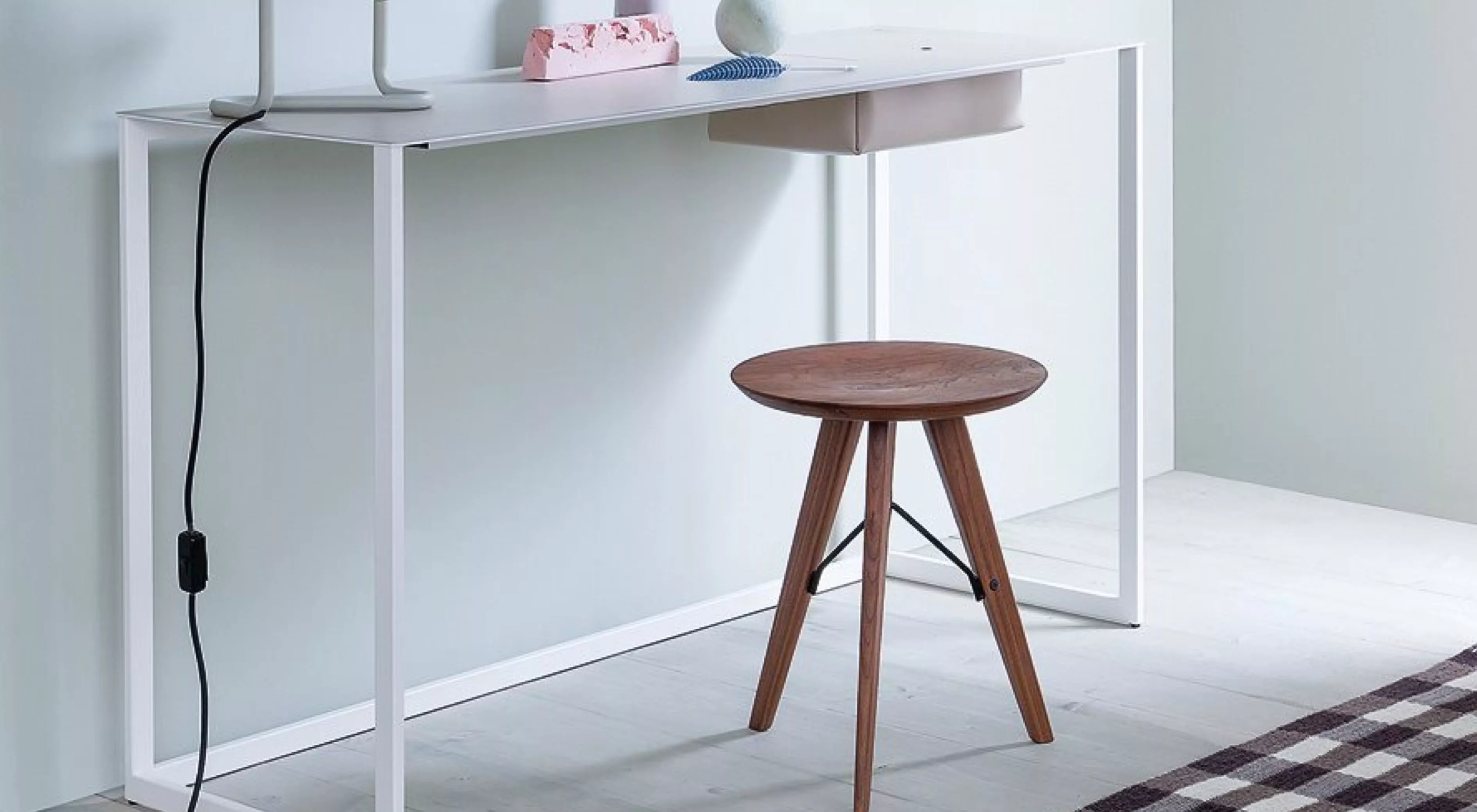 Schreibtisch Calamo von Zanotta in Weiß mit Holzstuhl, auf hellem Holzboden, minimalistisch eingerichtet, seitliche Perspektive.