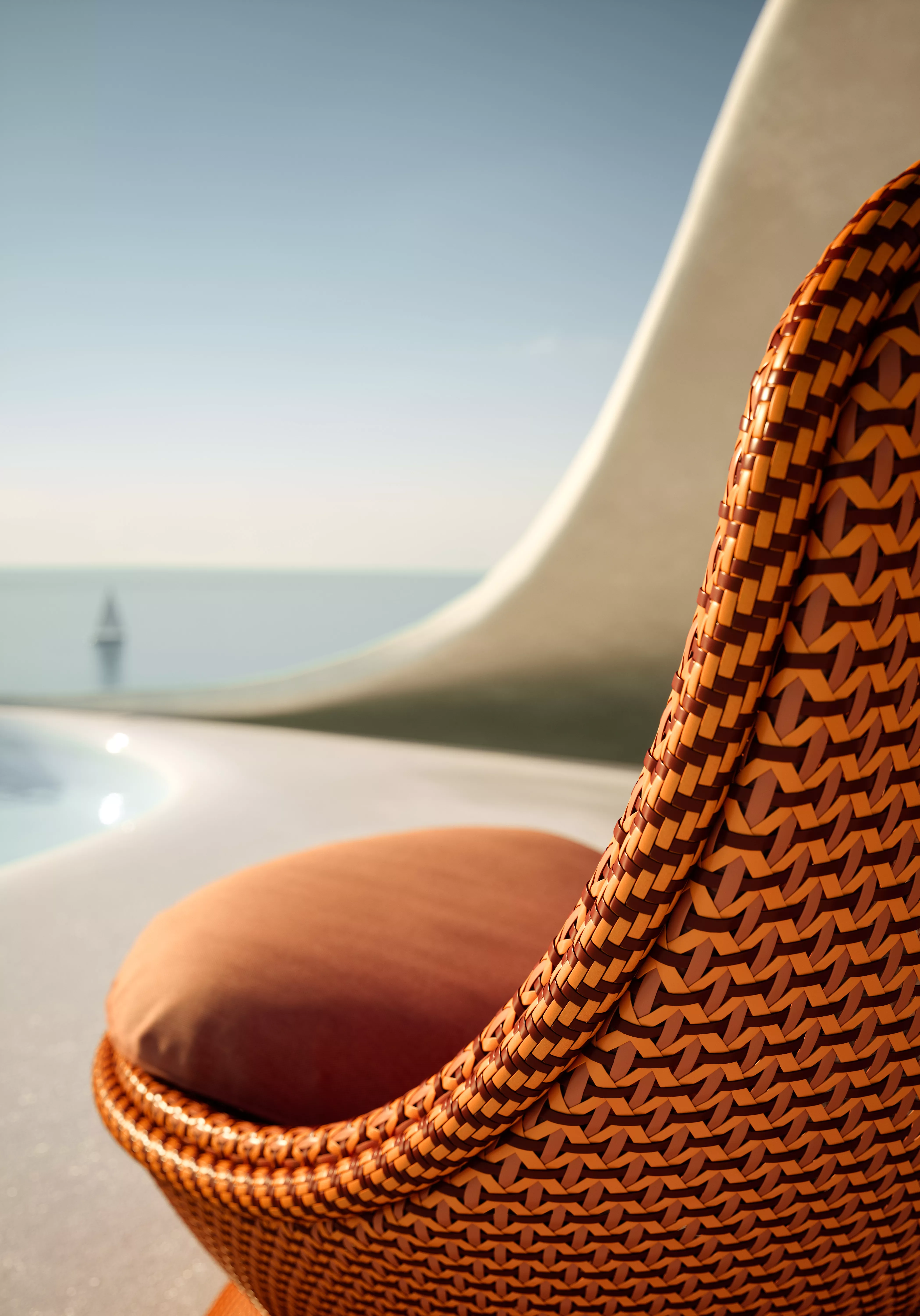 Dedon Endless Ocean Papyon Detailansicht eines geflochtenen Stuhls mit orangefarbenem Kissen im Freien mit Blick auf das Meer und ein Segelboot im Hintergrund