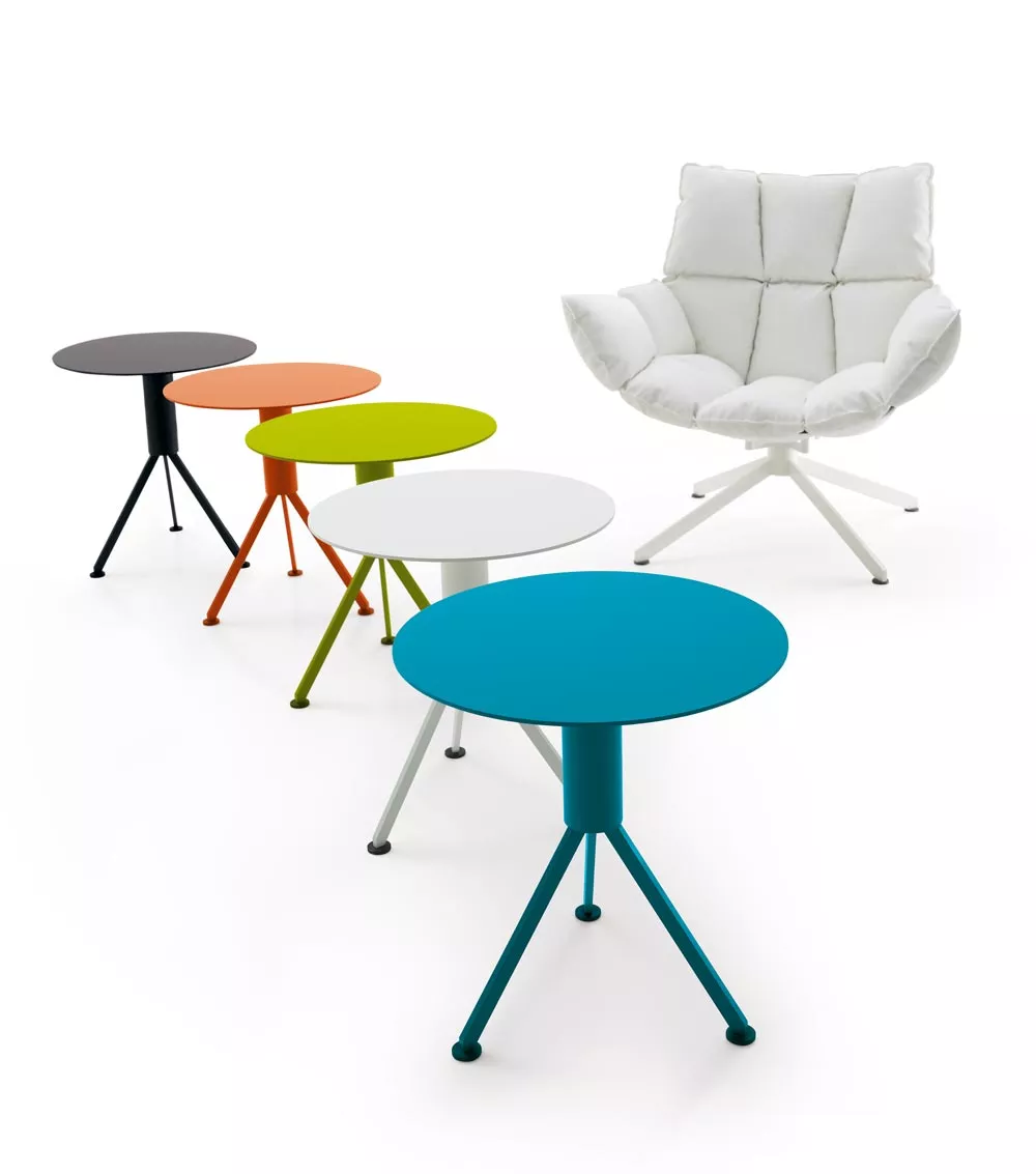 B&B Italia Husk Outdoor Loungesessel in Weiß mit fünf bunten Beistelltischen in verschiedenen Farben auf weißem Hintergrund.