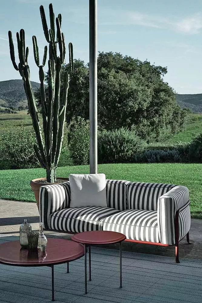 B&B Italia Borea Loungesofa in schwarzweißem Streifenmuster steht auf einer Terrasse mit Blick auf einen Garten mit Kakteen und Bäumen im Hintergrund
