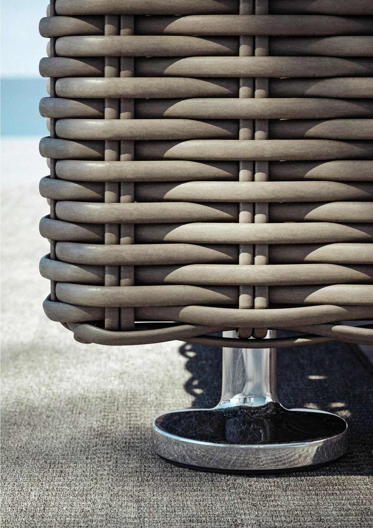 Detailaufnahme des Dedon Paros Gartenmöbels auf einer Terrasse mit Blick auf das Meer im Hintergrund